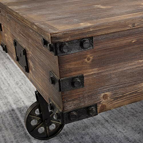 Close-up of a rustic wooden coffee table with metal accents and wheels.